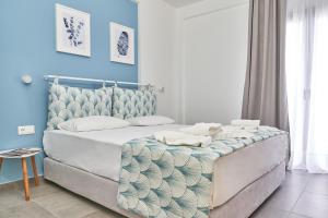 Schlafzimmer mit einem Bett mit blauer Wand in der Unterkunft Mougre studios in Polychrono