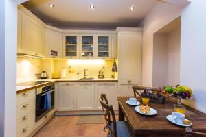 a kitchen with white cabinets and a wooden table at Anastasia's Venetian House in Rethymno