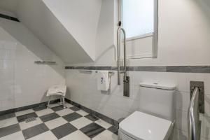 a bathroom with a toilet and a checkered floor at Casa Temprado in Seville