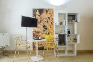 Zimmer mit einem Tisch und Stühlen sowie einem TV in der Unterkunft Palazzo Cavalli Pasquini in Verona