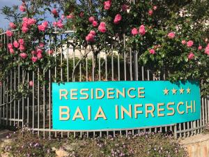 a sign on a fence with pink roses at Residence Baia Infreschi in Marina di Camerota