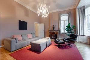 a living room with a couch and a red rug at Maison Haas Hustinx & Spa in Maastricht