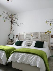 2 camas en una habitación con sábanas verdes y blancas en B&B Mario Relais, en Sorrento