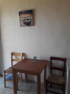 een eettafel, 2 stoelen en een schilderij bij Akrogiali in Gavdos