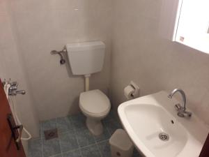 uma casa de banho com um WC branco e um lavatório. em Akrogiali em Karave