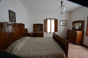 um quarto com uma cama grande e mobiliário em madeira em Il cedro em Molino del Pallone