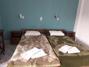 2 camas individuales en una habitación con paredes azules en Akrogiali en Gavdos