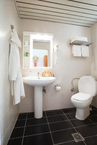 a bathroom with a sink and a toilet and a mirror at Acrotel Elea Beach in Elia