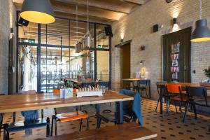 een restaurant met een grote houten tafel en stoelen bij Alibi Hostel Leeuwarden in Leeuwarden