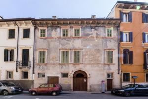 ein altes Gebäude mit einem Gemälde auf der Seite in der Unterkunft Palazzo Cavalli Pasquini in Verona