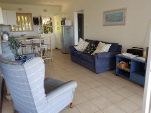 a living room with a blue couch and a kitchen at Aqua 180 in Pennington