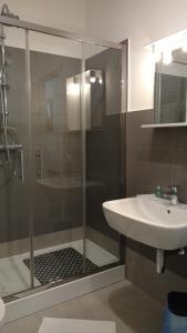 W łazience znajduje się szklana kabina prysznicowa i umywalka. w obiekcie Casa Giulia w Mestre