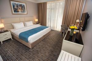 a hotel room with a bed and a television at City Avenue Hotel in Tbilisi City