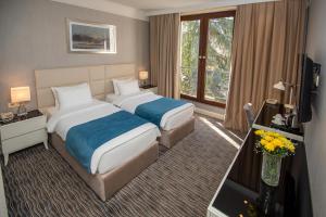 a hotel room with two beds and a television at City Avenue Hotel in Tbilisi City +77 photos