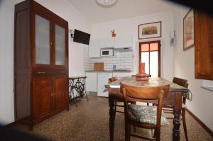 a kitchen with a table and chairs and a table and a cabinet at Il cedro in Molino del Pallone