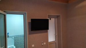 a flat screen tv on the wall of a room at Alisher B&B Hotel in Samarkand