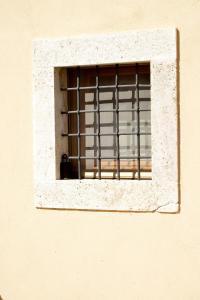 uma janela com barras na lateral de um edifício em VINO SUITE em San Quirico dʼOrcia