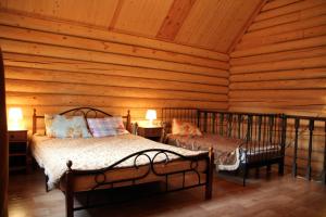 1 dormitorio con 2 camas en una cabaña de madera en Velikoe Ozero - Valday, en Simanikha