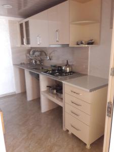 a kitchen with white cabinets and a counter top at Hotel Lika in Batumi +30 photos
