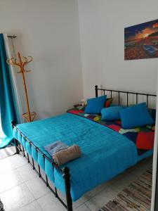 a bedroom with a bed with blue sheets and blue pillows at Alekas Pool and Garden Home in Paphos