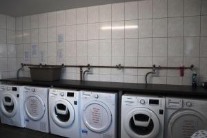 a laundry room with three washing machines and a counter at Hotel M24 - Alle Zimmer mit Küchenzeile & Self-CheckIn in Vechta