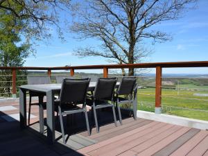 a table and chairs on a deck with a view at Spacious Chalet in Vielsalm with Garden in Vielsalm