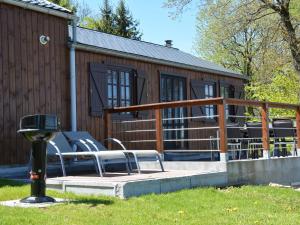 a building with a deck with chairs in front of it at Spacious Chalet in Vielsalm with Garden in Vielsalm