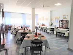 a dining room with white tables and chairs at Stella Maris Casa per ferie sul mare in Anzio +19 photos