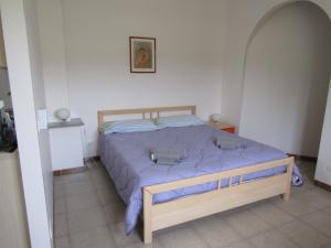 a bedroom with a bed with a blue comforter at Case Vacanze Panarea by CivicoVentiquattro in Cava dʼAliga