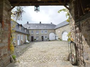uma entrada para um castelo com um pátio de pedra em Medieval farmhouse with private garden em Waimes