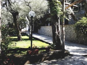 una luz de la calle en un parque con árboles y una pared en La Scaletta Casa Vacanze en Massa Lubrense
