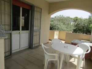 a patio with a white table and chairs on a balcony at Case Vacanze Panarea by CivicoVentiquattro in Cava dʼAliga +16 photos