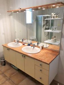 a bathroom with two sinks and a large mirror at Aux Cyprès du Sud : mer et montagne in Logrian-et-Comiac-de-Florian