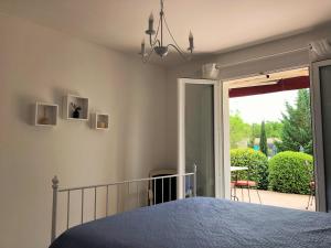 une chambre avec un lit et une porte coulissante en verre dans l'établissement Aux Cyprès du Sud : mer et montagne, à Logrian-et-Comiac-de-Florian 188 autres photos