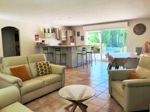 un salon avec deux canapés et une cuisine dans l'établissement Aux Cyprès du Sud : mer et montagne, à Logrian-et-Comiac-de-Florian