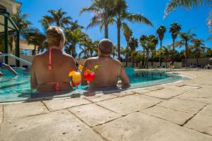 two men sitting in the swimming pool at a resort at Mirachoro Carvoeiro in Carvoeiro