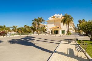 a large building with palm trees in front of it at Mirachoro Carvoeiro in Carvoeiro