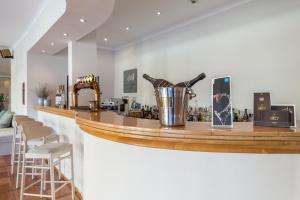a bar with a wooden counter with stools at it at Mirachoro Carvoeiro in Carvoeiro