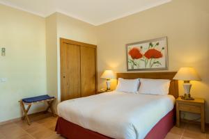 a bedroom with a large white bed with two lamps at Mirachoro Carvoeiro in Carvoeiro