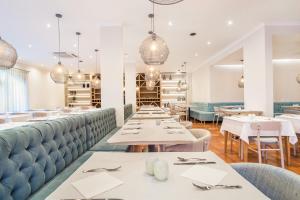 a restaurant with white tables and blue booths at Mirachoro Carvoeiro in Carvoeiro