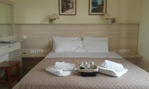 Una cama con dos toallas y dos vasos. en Alexandros Studios en Kalamaki