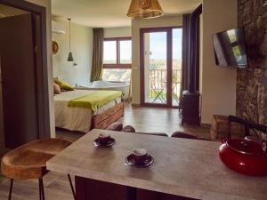 Casas del CerroCasas Rurales Maribel - Complejo Moradas del Cerro 1 - Suites con Jacuzzi en Alcalá del Júcar的一间酒店客房,配有床和一张桌子,上面有杯子