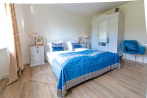 ein Schlafzimmer mit einem blauen Bett und einem blauen Stuhl in der Unterkunft DAS KLEINE HOTEL IPHOFEN, Iphofens kleines Secret in Iphofen