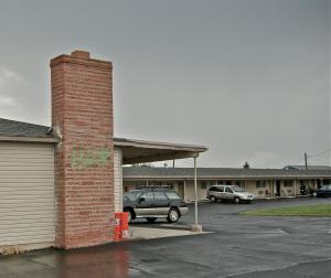 a brick building with a car parked in a parking lot at Hub Motel in Redmond