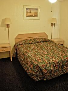 a hotel room with a bed and two lamps at Hub Motel in Redmond