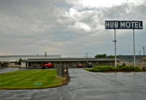 a huff motel sign in front of a parking lot at Hub Motel in Redmond