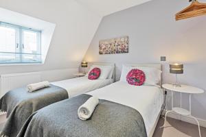 two twin beds in a room with a window at Park View House - By My Getaways in Brighton & Hove