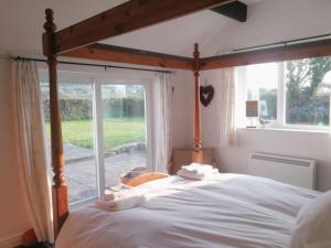 a bedroom with a large bed with a large window at Gors Eilian in Amlwch