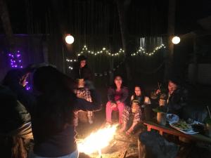 a group of people sitting around a fire at THE GINGKO EYRIE in Kalimpong
