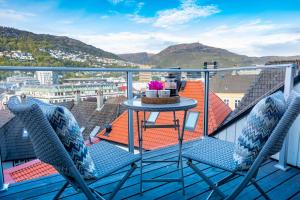 balkon z 2 krzesłami i stołem na dachu w obiekcie 2 Døtre Apartments w Bergen